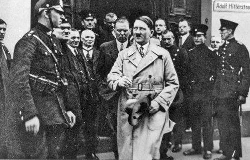 Adolf Hitler leaves the regional court in Frankenthal. The photo was manipulated and an Adolf Hitler Straße plaque was added to create a postcard in 1933